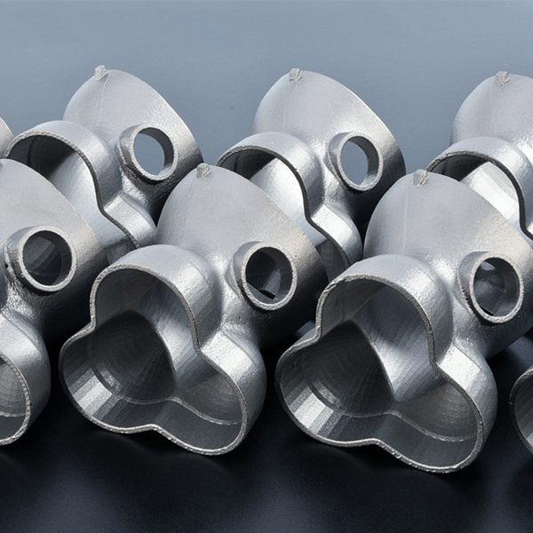 三方接合を備えた光沢のある銀色の金属製パイプ継手のコレクションで、反射する黒い表面上に密に配置されています。各継手は滑らかで丸いエッジと端に円形の開口部を備えており、中国の OEM および ODM 製造会社の精度を実証しています。